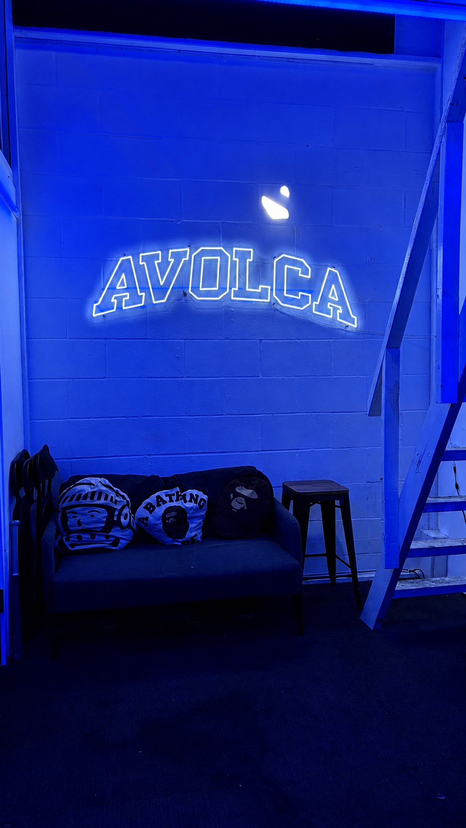 The AVOLCA neon sign glowing above the lounge seating in the studio, Upper Clapton